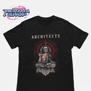 Può includere: Una t-shirt nera a maniche corte con la parola ARCHITECTS in testo bianco sopra un grafico di uno scheletro in posizione di meditazione seduta. Lo scheletro è reso in tonalità di grigio e rosso, circondato da un motivo geometrico circolare rosso e nero.
