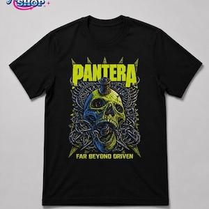 May include: A black short-sleeve t-shirt featuring a graphic print of a skull pierced by a drill bit, surrounded by barbed wire. The text PANTERA appears in yellow above the skull, and FAR BEYOND DRIVEN is printed in yellow below the graphic.