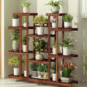 Può includere: Un portapiante in legno marrone scuro a più livelli, pieno di varie piante in vaso. Il supporto ha più ripiani di diverse dimensioni, creando un'esposizione visivamente accattivante per il giardinaggio indoor. Le piante includono una varietà di fogliame verde e fiori colorati.