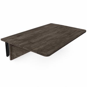 May include: A wall-mounted rectangular folding table with a dark gray wood grain finish. The tabletop features rounded corners and is supported by a vertical wooden panel and a black metal hinge mechanism attached to the side for folding functionality.