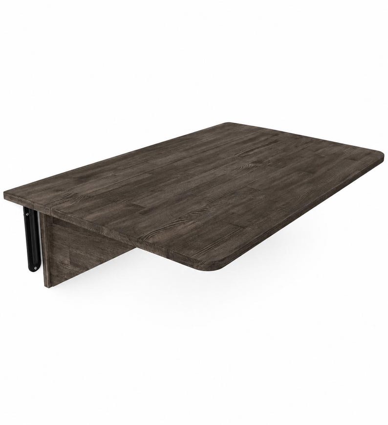 May include: A wall-mounted rectangular folding table with a dark gray wood grain finish. The tabletop features rounded corners and is supported by a vertical wooden panel and a black metal hinge mechanism attached to the side for folding functionality.