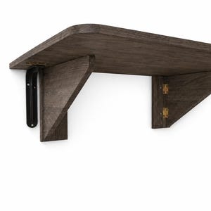 May include: A dark brown wooden wall-mounted folding shelf with a smooth, rounded front edge. The shelf features a black metal bracket on the left side and two gold-colored metal hinges connecting the triangular support piece to the main shelf board.