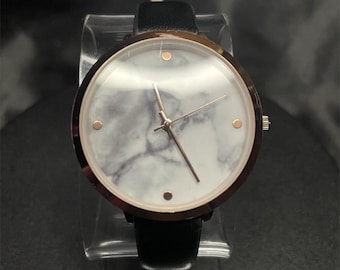 Reloj analógico Accutime para mujer con esfera de mármol, caja de acero inoxidable color oro rosa y correa de cuero.