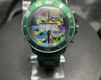 Reloj de pulsera LED unisex para niños TMNT Accutime con correa de caucho verde y bisel cronógrafo.