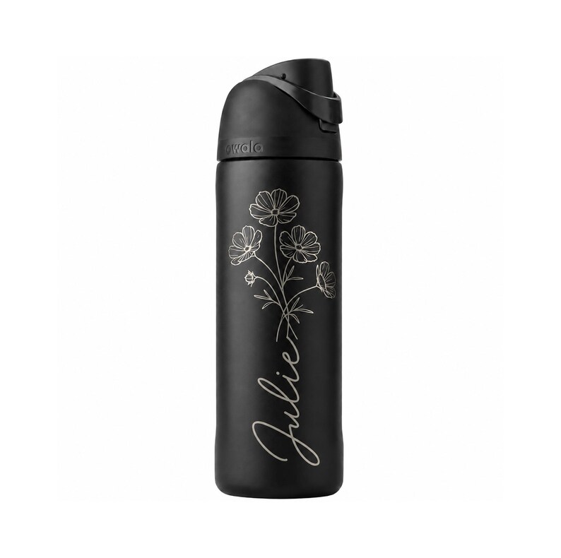 May include: A black Owala water bottle with a flip-top lid. The bottle features a floral design and the name "Julie" in cursive script. The bottle is designed to keep drinks cold and is ideal for everyday use.