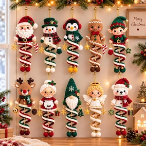 May include: A collection of ten crocheted Christmas ornaments featuring characters including Santa, a snowman, a penguin, a gingerbread person, an elf, a reindeer, Mrs. Claus, a gnome, an angel, and a polar bear, each with a spiral tail.