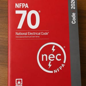 May include: A red book titled NFPA 70 National Electrical Code 2026. The cover features large white text, a circular white logo with the letters nec and two lightning bolts, and a small NFPA flame icon at the bottom left corner on a red background.