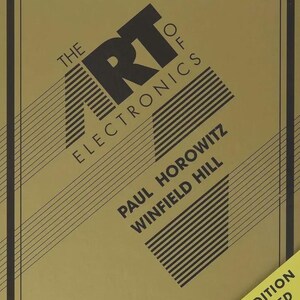 May include: A hardcover book titled The Art of Electronics by Paul Horowitz and Winfield Hill. The cover is olive green with black text and diagonal line graphics. A yellow corner banner indicates it is the Third Edition Improved.