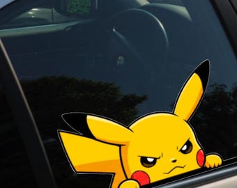 May include: A yellow Pikachu character decal applied to a car window. The character has long ears with black tips, red circular cheeks, and a focused, determined facial expression. The decal shows the character peeking over the bottom window edge.