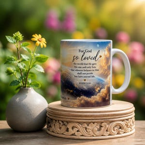 May include: A white ceramic mug featuring a printed image of the Earth from space with clouds and a bright sun. The text reads: For God so loved the world that He gave His one and only Son, that whoever believes in Him shall not perish but have eternal life. JOHN 3:16.