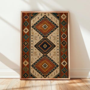 May include: A framed print of a rug design. The rug features a beige backdrop with geometric patterns in orange, blue, and brown. The wooden frame enhances the warm tones of the artwork, creating a cosy aesthetic. The frame is approximately 60 cm in height.