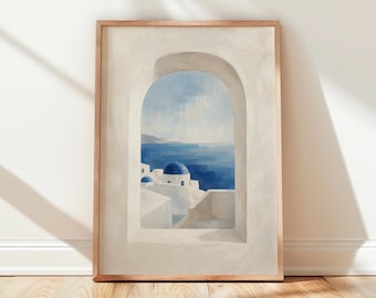 May include: A framed art print depicting a coastal scene. The artwork features a white archway framing a view of blue sea and sky, with white buildings and blue domes. The frame is a light brown color.