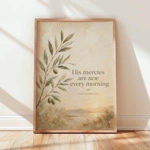 May include: A framed wall art print featuring a textured beige background with an olive branch illustration on the left. The text reads: His mercies are new every morning, Lamentations 3:23. Below the text is a landscape of hills and water.