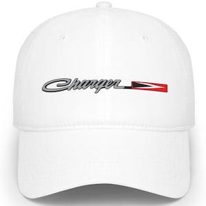 Puede incluir: Gorra de béisbol blanca con la palabra "Charger" en una fuente estilizada, delineada en negro y un acento rojo y negro. La gorra tiene una visera curva y un diseño clásico de seis paneles.