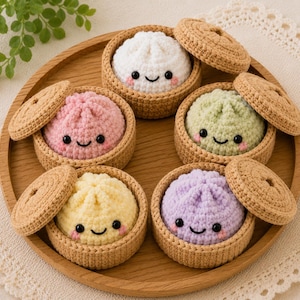 May include: Five crocheted plush dumplings in various pastel colors including white, pink, light green, yellow, and lavender. Each dumpling features a smiling face with black eyes and pink cheeks, nestled inside a small tan crocheted steamer basket.
