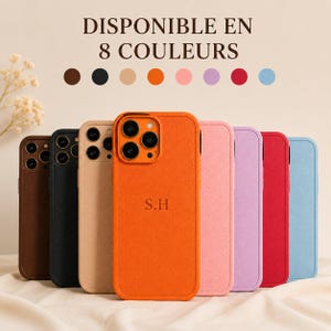 Op de afbeelding: Acht smartphonehoesjes in bruin, zwart, beige, oranje, roze, paars, rood en lichtblauw. Het oranje hoesje heeft de inscriptie S.H. De tekst DISPONIBLE EN 8 COULEURS staat boven de hoesjes met bijbehorende gekleurde cirkels.