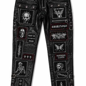 Könnte beinhalten: Schwarze Hose mit verschiedenen rechteckigen Aufnähern mit weißen Grafikdrucken, darunter Totenköpfe, ein Schmetterling, ein Schwert und Texte wie "no gods no masters", "lost in silence", "past is dead" und "nothing lasts". Die Hose hat Metallnieten.