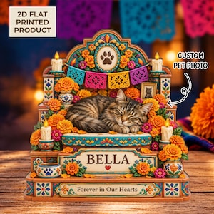 May include: A decorative memorial display featuring a sleeping tabby cat surrounded by orange marigold flowers, candles, and colorful papel picado banners. The base includes the name BELLA and the text Forever in Our Hearts with a paw print icon.