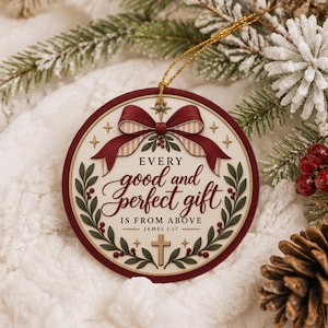 Könnte beinhalten: Ein runder Weihnachtsanhänger mit dunkelrotem Rand und cremefarbener Mitte. Er zeigt eine rote Schleife oben, grüne Stechpalmenblätter mit roten Beeren, ein kleines Kreuz und den Text: EVERY good and perfect gift IS FROM ABOVE JAMES 1:17.
