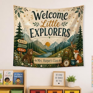 May include: A rectangular wall tapestry featuring a mountain landscape with a bear, a fox, a deer, and a backpack. The text reads Welcome Little EXPLORERS and Mrs. Harper's Class, with signs saying Be Kind, Be Curious, and Be Brave in dark green and brown.
