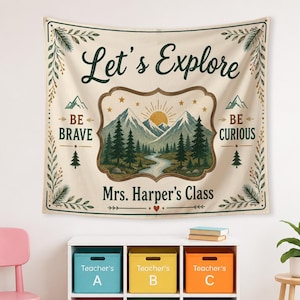 May include: A rectangular fabric wall hanging featuring the text Let's Explore, Be Brave, Be Curious, and Mrs. Harper's Class. The design includes a central illustration of mountains, a sun, a river, and pine trees, framed by botanical leaf borders.