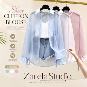 Könnte beinhalten: Drei transparente Chiffonblusen in Hellblau, Weiß und Rosa, jeweils mit Kragen, durchgehender Knopfleiste und langen Ärmeln mit Rüschenbündchen und Bindedetails. Der Text lautet: Sheer CHIFFON BLOUSE, LIGHT, AIRY, ELEGANT, LIGHTWEIGHT & BREATHABLE, SOFT CHIFFON FABRIC, RUFFLE CUFFS WITH TIE DETAIL, 3 COLORS, Zarela Studio, TIMELESS STYLE, MADE FOR YOU.