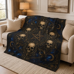 May include: A dark blue and gold throw blanket featuring a central pentagram surrounded by five detailed human skulls. The design includes intricate filigree patterns, crescent moons, and a starry celestial background across the fabric surface.
