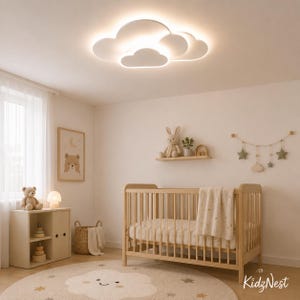 May include: A white cloud-shaped LED ceiling light fixture with a soft glow, installed in a room featuring a wooden crib, a wooden shelf with a plush rabbit, a wooden storage unit, a round rug with a cloud design, and a star-shaped wall hanging.