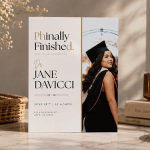 Op de afbeelding: Een rechthoekige afstudeeraankondigingskaart met de tekst Phinally Finished, Dr. Jane Davicci en evenementdetails. Het ontwerp bevat rechts een foto van een afgestudeerde in een zwarte toga en baret en aan de linkerkant een witte ruimte.