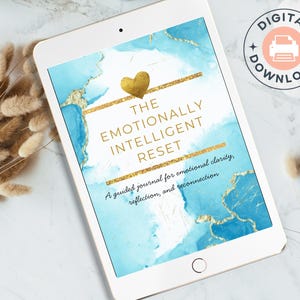Könnte beinhalten: Ein weißes Tablet zeigt einen digitalen Download eines Journals mit dem Titel "The Emotionally Intelligent Reset". Das Cover zeigt ein blaues und goldenes Aquarelldesign. Ein "Digitaler Download"-Badge ist oben rechts sichtbar.