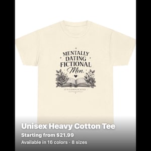 May include: A cream-coloured short-sleeve t-shirt with a speckled texture. The front features a black graphic of an open book flanked by roses, with the text "MENTALLY DATING FICTIONAL Men." and "IT'S COMPLICATED." printed in a decorative font.