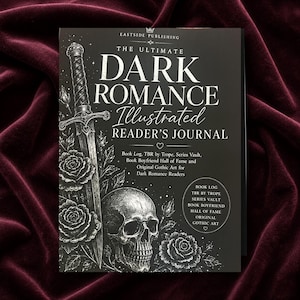 Puede incluir: Un libro negro titulado The Ultimate Dark Romance Illustrated Reader's Journal. La portada presenta dibujos en blanco de una espada, rosas y una calavera. El texto incluye Book Log, TBR by Trope, Series Vault, Book Boyfriend Hall of Fame y Original Gothic Art.