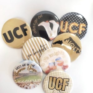 May include: A collection of eight circular pin-back buttons featuring various designs related to UCF. The buttons display text including UCF, Charge on, Go Knights, Knights, Meet me in the Bounce House, and to the knights, with graphics of stadium scenes, drinks, and patterns.