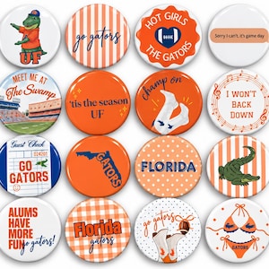 May include: A collection of sixteen round pinback buttons featuring University of Florida themes. Designs include a mascot, football stadium, gator illustrations, orange and blue patterns, and text such as Go Gators, Florida, and game day slogans.