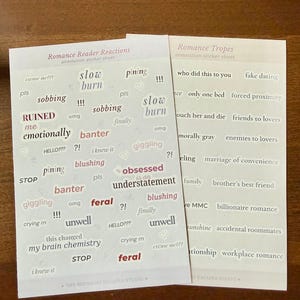 Op de afbeelding: Twee rechthoekige stickervellen met tekst voor romance-lezers. Het linker vel, getiteld Romance Reader Reactions, bevat zinnen zoals slow burn, sobbing, RUINED en feral. Het rechter vel, Romance Tropes, bevat termen zoals fake dating, forced proximity en enemies to lovers.