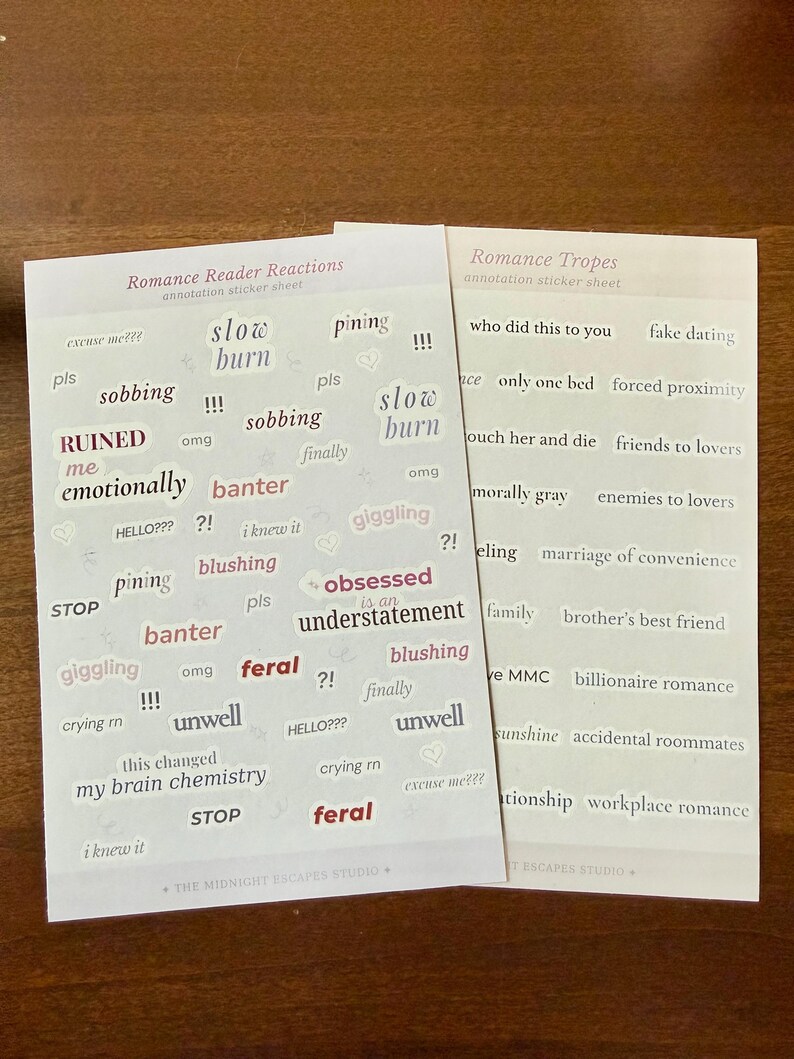 Op de afbeelding: Twee rechthoekige stickervellen met tekst voor romance-lezers. Het linker vel, getiteld Romance Reader Reactions, bevat zinnen zoals slow burn, sobbing, RUINED en feral. Het rechter vel, Romance Tropes, bevat termen zoals fake dating, forced proximity en enemies to lovers.