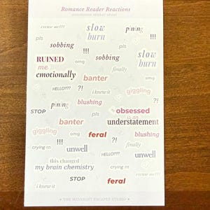Op de afbeelding: Een rechthoekig stickervel met de titel Romance Reader Reactions met diverse zinnen in verschillende lettertypes en kleuren, waaronder slow burn, sobbing, RUINED me emotionally, banter, blushing, obsessed, feral en this changed my brain chemistry.