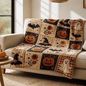 Könnte beinhalten: Eine rechteckige Wohndecke mit Patchwork-Design aus abwechselnden schwarzen und beigefarbenen Karofeldern. Das Muster zeigt gestickte Motive von orangefarbenen Kürbissen, weißen Geistern, schwarzen Fledermäusen, Hexenhüten und braunen Blumen.