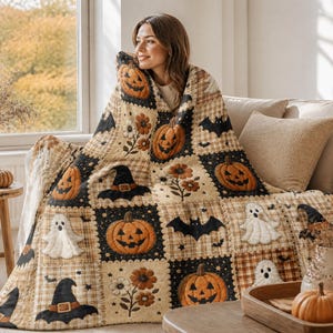 Puede incluir: Una colcha de patchwork con un patrón repetitivo de calabazas de Halloween, fantasmas blancos, murciélagos negros, sombreros de bruja y flores naranjas. El diseño alterna entre fondos negros y cuadrados de cuadros beige.