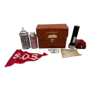 May include: An auto emergency kit with a brown leatherette case, a flashlight, and a red SOS flag. The kit includes tire inflator and sealer, a fire extinguisher, and a small first aid kit.