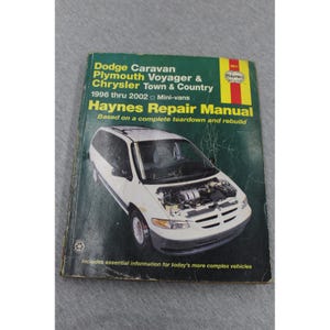 May include: A Haynes repair manual for 1996 thru 2002 Dodge Caravan, Plymouth Voyager, and Chrysler Town & Country mini-vans. The green cover features a white mini-van with its hood open, displaying the engine, and yellow text throughout.
