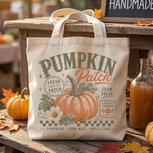 May include: A cream-colored canvas tote bag featuring a graphic print with the text PUMPKIN Patch, FRESH FROM THE PATCH, FARM FRESH, LOCALLY GROWN, and PUMPKINS CORN MAZE APPLE CIDER. The design includes a large orange pumpkin and green leaves.
