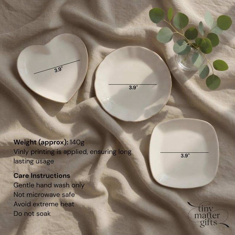 May include: Three off-white ceramic plates in heart, round, and square shapes, each measuring 3.9 inches in width. The set includes text detailing a weight of 140g, vinyl printing, and care instructions including gentle hand wash only.