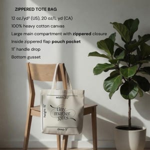 Pu&ograve; includere: Una borsa tote beige con cerniera in tela di cotone pesante. Presenta un ampio scomparto principale con chiusura a zip, una tasca interna con zip, manici con caduta di 28 cm e un soffietto sul fondo. Il testo recita: tiny matter gifts.