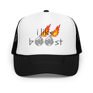 May include: A white and black trucker hat featuring a graphic print on the front panel. The design includes the text "i like boost" with two turbocharger illustrations replacing the letter "o," each topped with orange and yellow flames.