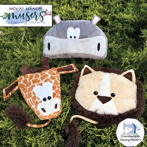 May include: Three plush animal head sewing patterns: a giraffe, a lion, and a hippopotamus. The patterns are downloadable and include instructions for sewing the animals. The animals are all smiling and have friendly faces.