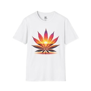 May include: White t-shirt with a vibrant cannabis leaf design. The leaf is depicted in shades of purple, red, orange, and yellow, with a sunset effect at its core. The design is centrally placed on the front of the shirt.