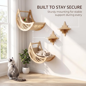 Puede incluir: Dos hamacas de madera para gatos en forma de media luna y dos estantes de pared en forma de estrella montados en una pared blanca. El texto BUILT TO STAY SECURE y Sturdy mounting for stable support during every es visible.
