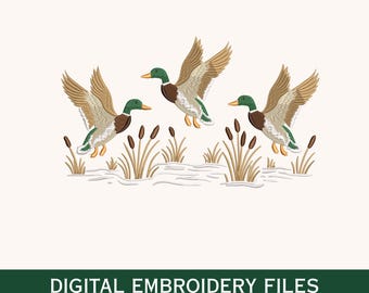 May include: Digital embroidery files featuring three ducks in flight, with detailed brown, green, and tan plumage. The ducks are depicted above cattails and water, with the text "DIGITAL EMBROIDERY FILES" and file type abbreviations below.