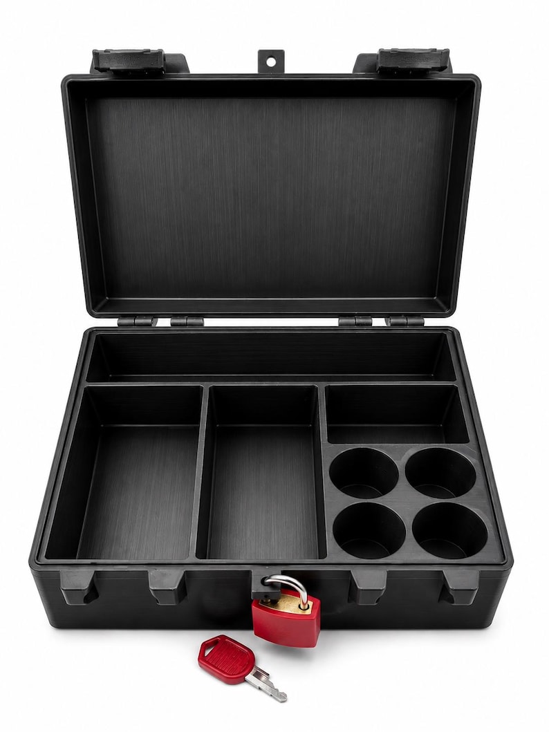 Puede incluir: Un malet&iacute;n de almacenamiento de pl&aacute;stico negro con tapa abierta, que presenta un interior dividido con dos compartimentos rectangulares y cuatro ranuras circulares. Incluye un candado rojo en el cierre frontal y una llave roja a juego cerca.